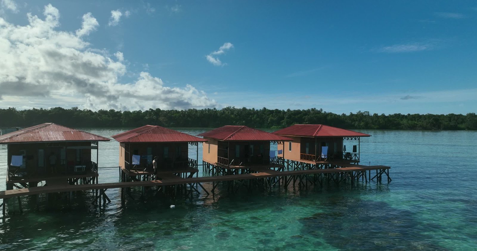 Drone view along the overwater villas and clear reef