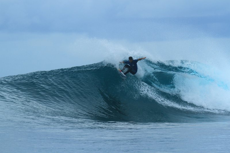 Shortys: A surfer riding a wave in the Banyak Islands